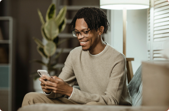 homem negrou sorrindo segurando o celular